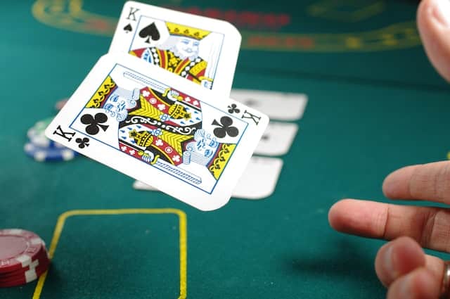 Ein Pokerspieler wirft ein Blatt mit zwei Königen auf einen Pokertisch ab